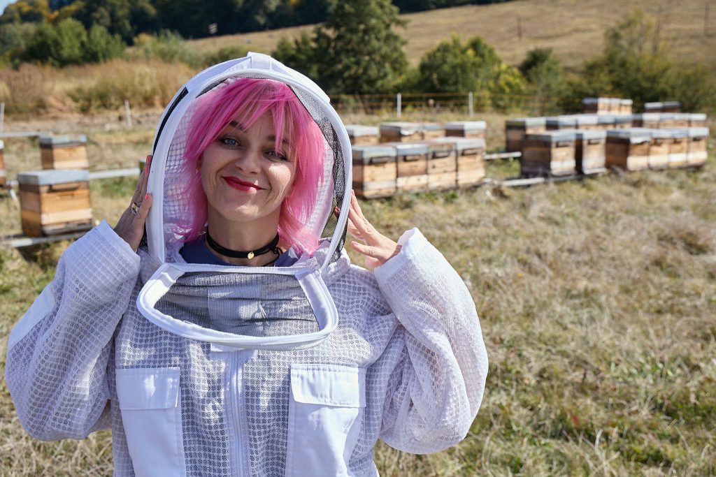 Gianina Corondan, în costum de apicultor, lângă o stupină